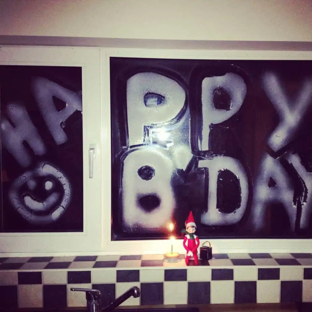 Elf on the Shelf Antics - Spray painting the windows