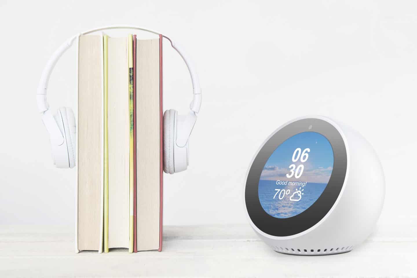 books with a headphone over the top next to an alexa