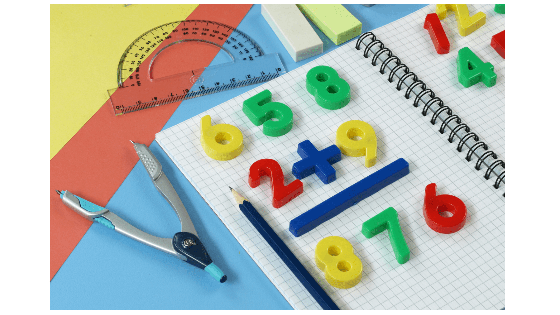 Math equipment including plastic magnetic numbers on math notepaper.