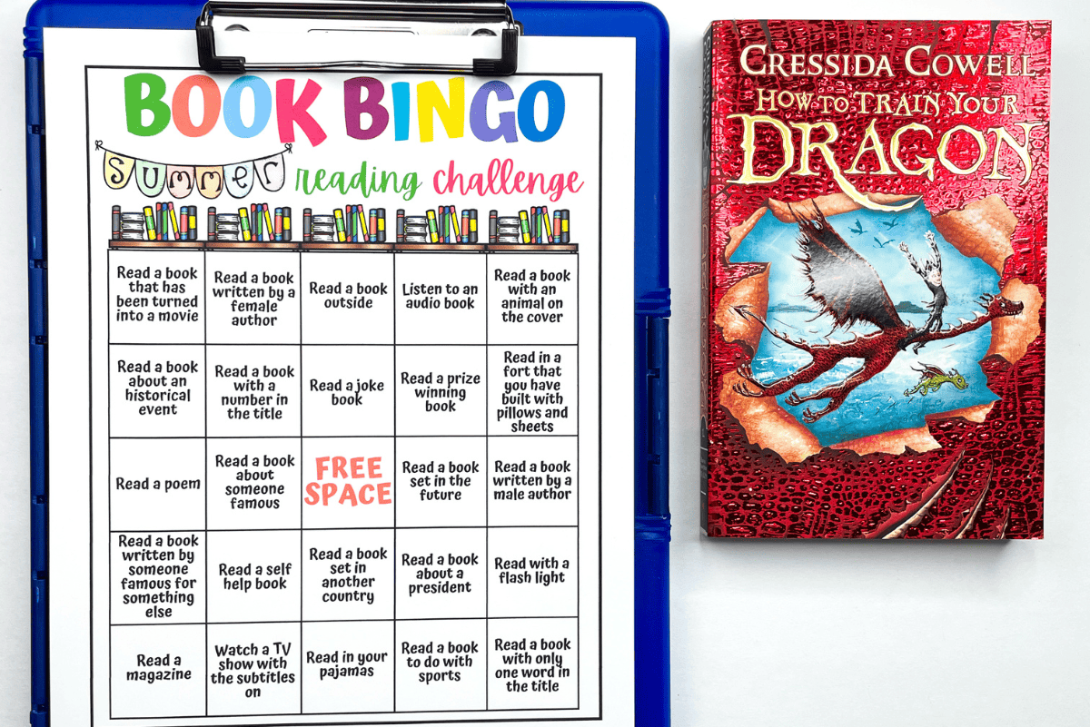 A summer reading challenge "Book Bingo" worksheet is clipped to a blue clipboard next to a copy of How to Train Your Dragon by Cressida Cowell. The bingo board contains prompts like “Read a book written by a female author” and “Read a book with an animal on the cover,” encouraging kids to complete reading tasks for a fun literacy activity.