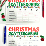 Close-up of completed Christmas Scattergories game boards with words filled in, holiday beads, and red and pink pens.