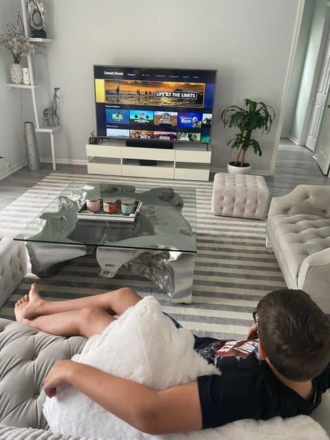 Teen boy watching curiosity stream in his living room watching tv while learning!