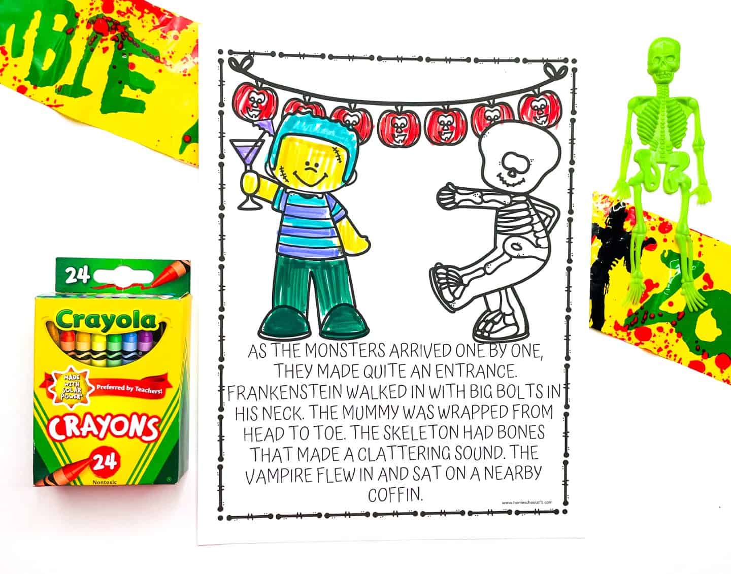 A Halloween-themed coloring page is centered on a white background, featuring a boy in a helmet holding a drink and a dancing skeleton under a garland of jack-o'-lanterns. The boy is colored in with markers. Below the image is a short Halloween story mentioning Frankenstein, a mummy, a skeleton, and a vampire. Surrounding the page are Halloween props including a green skeleton, a box of Crayola crayons, and yellow caution tape labeled “ZOMBIE.”