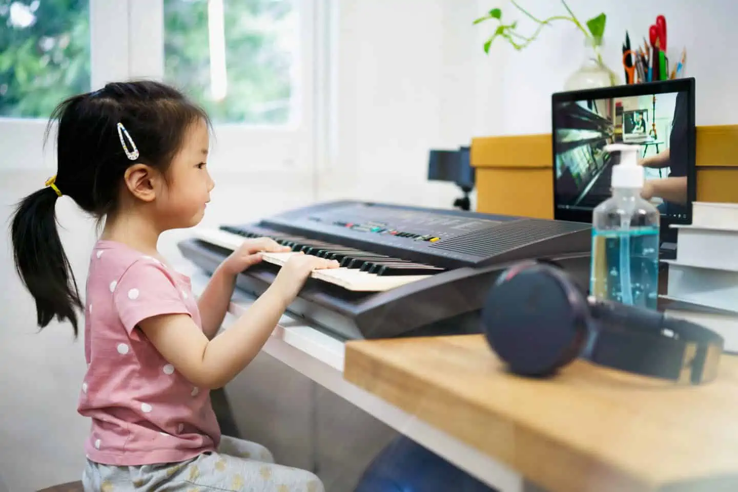 young girl playing a keyboard in front of an Ipad