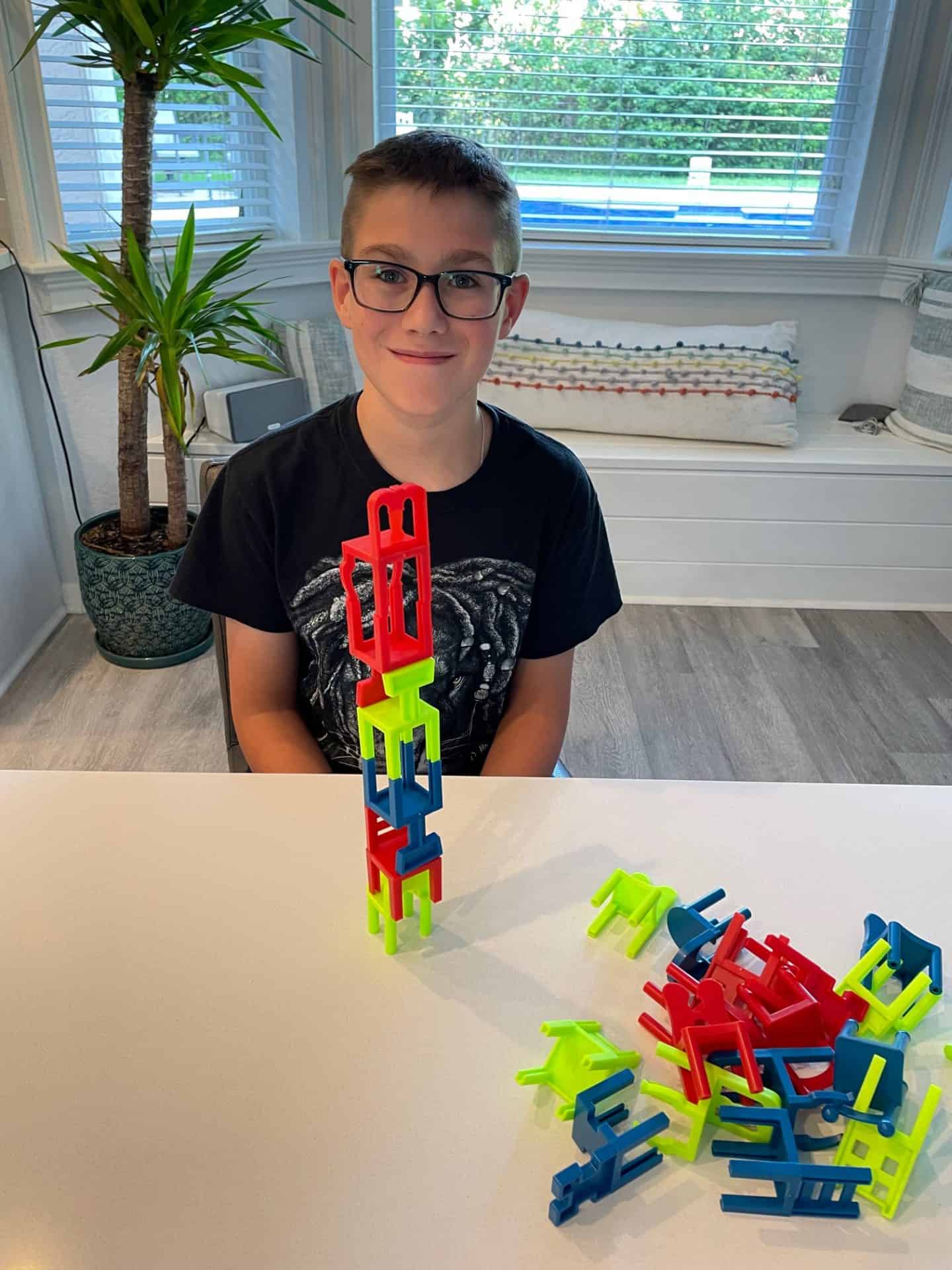 boy playing chairs, the stacking game