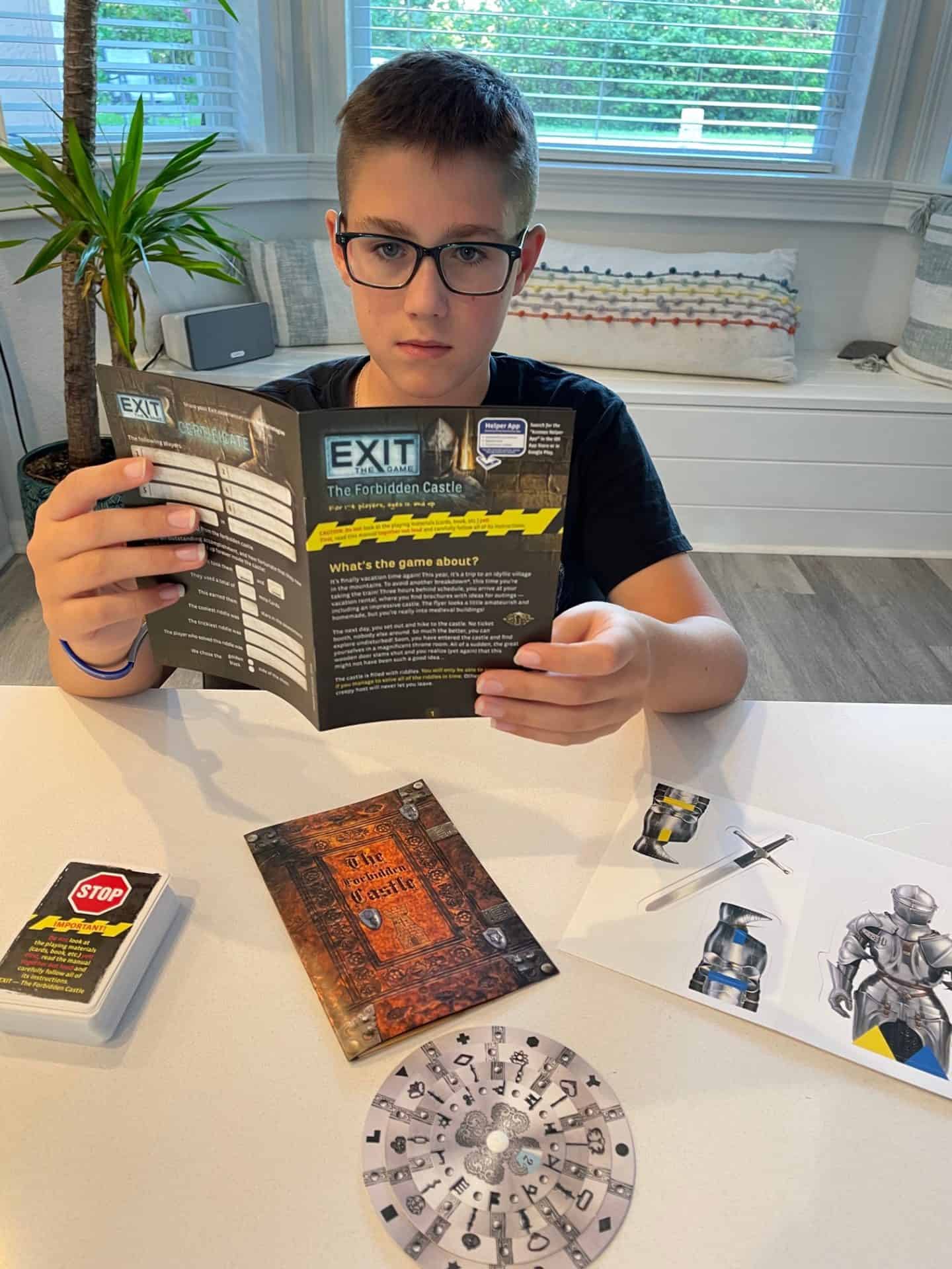 Boy reading the rules to EXIT The Forbidden Castle