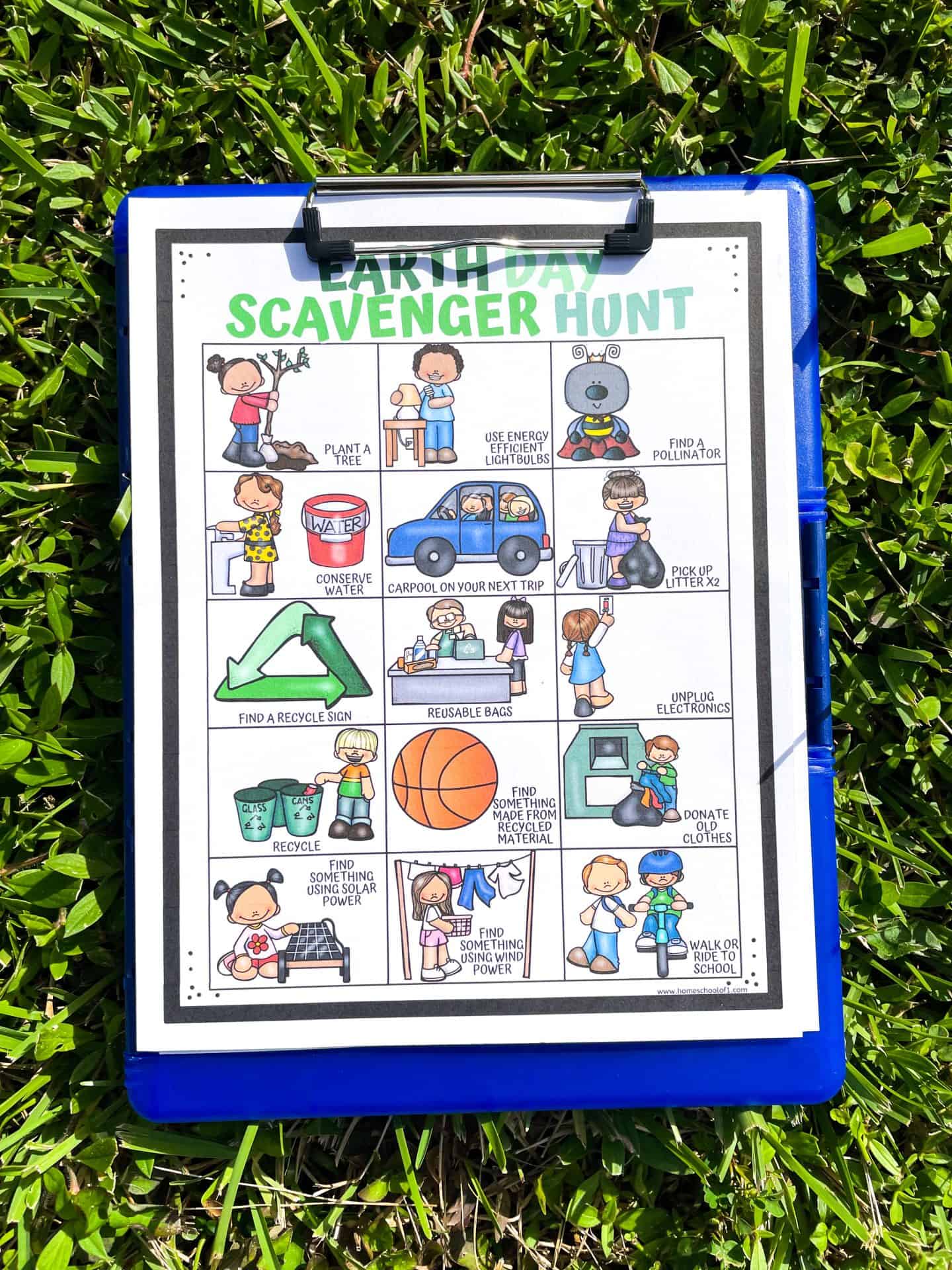 earth day scavenger hunt worksheet on a blue clipboard sitting on the grass.
