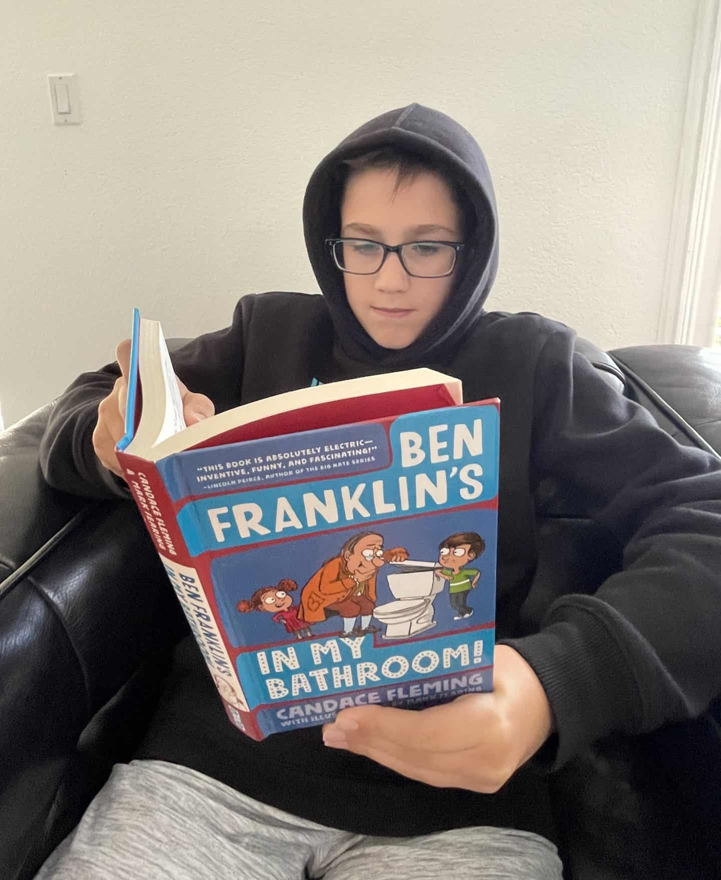 Boy reading Ben Franklin's in my bathroom book
