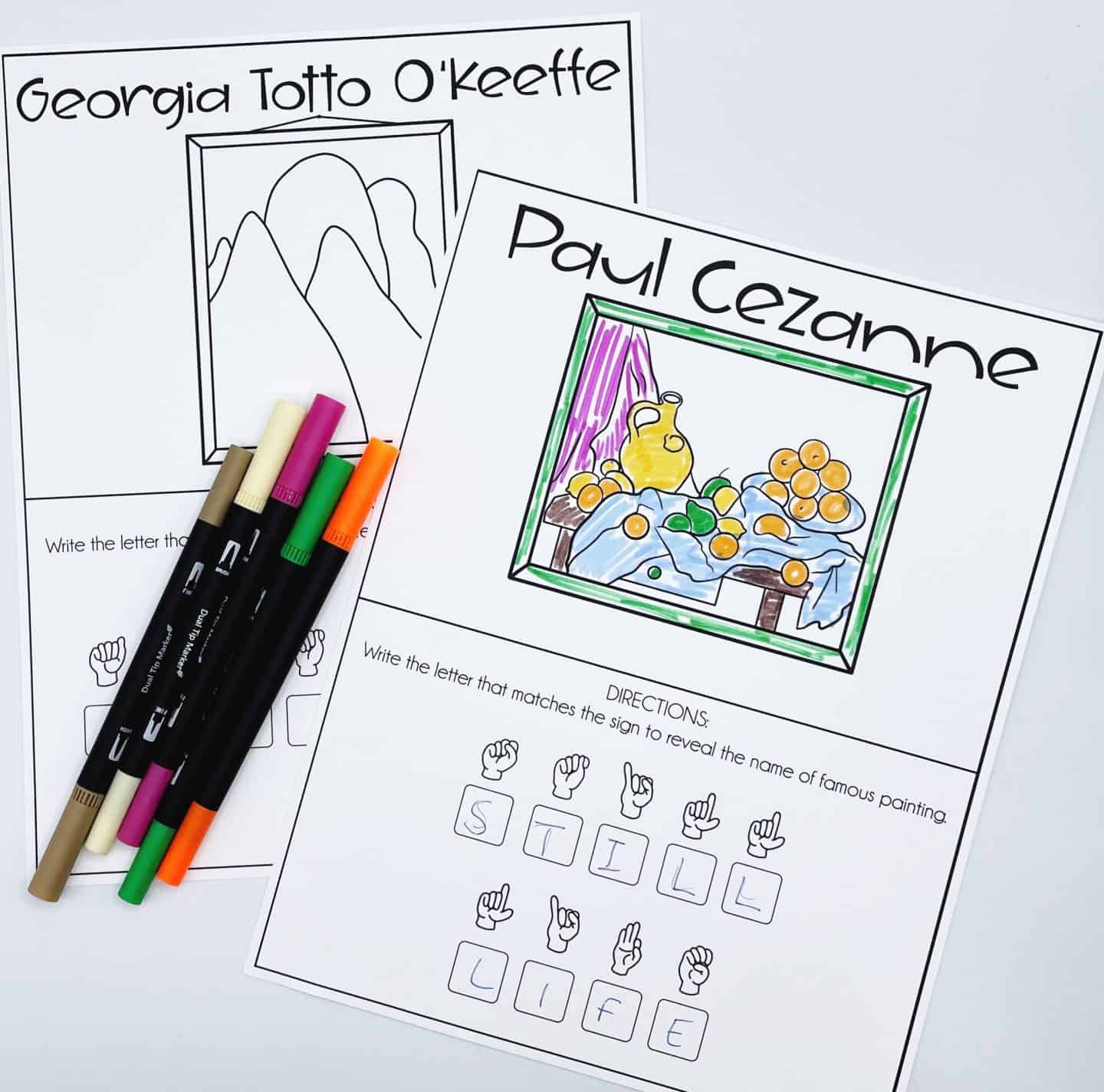 Two ASL art worksheets featuring famous artists. The first worksheet, partially colored, represents Paul Cezanne's "Still Life" with a vibrant fruit and vase scene. Below the painting, ASL hand signs spell out “STILL LIFE.” The second worksheet, for Georgia Totto O’Keeffe, is uncolored and shows a minimalist mountain sketch. Several dual-tip markers lie across the sheets.