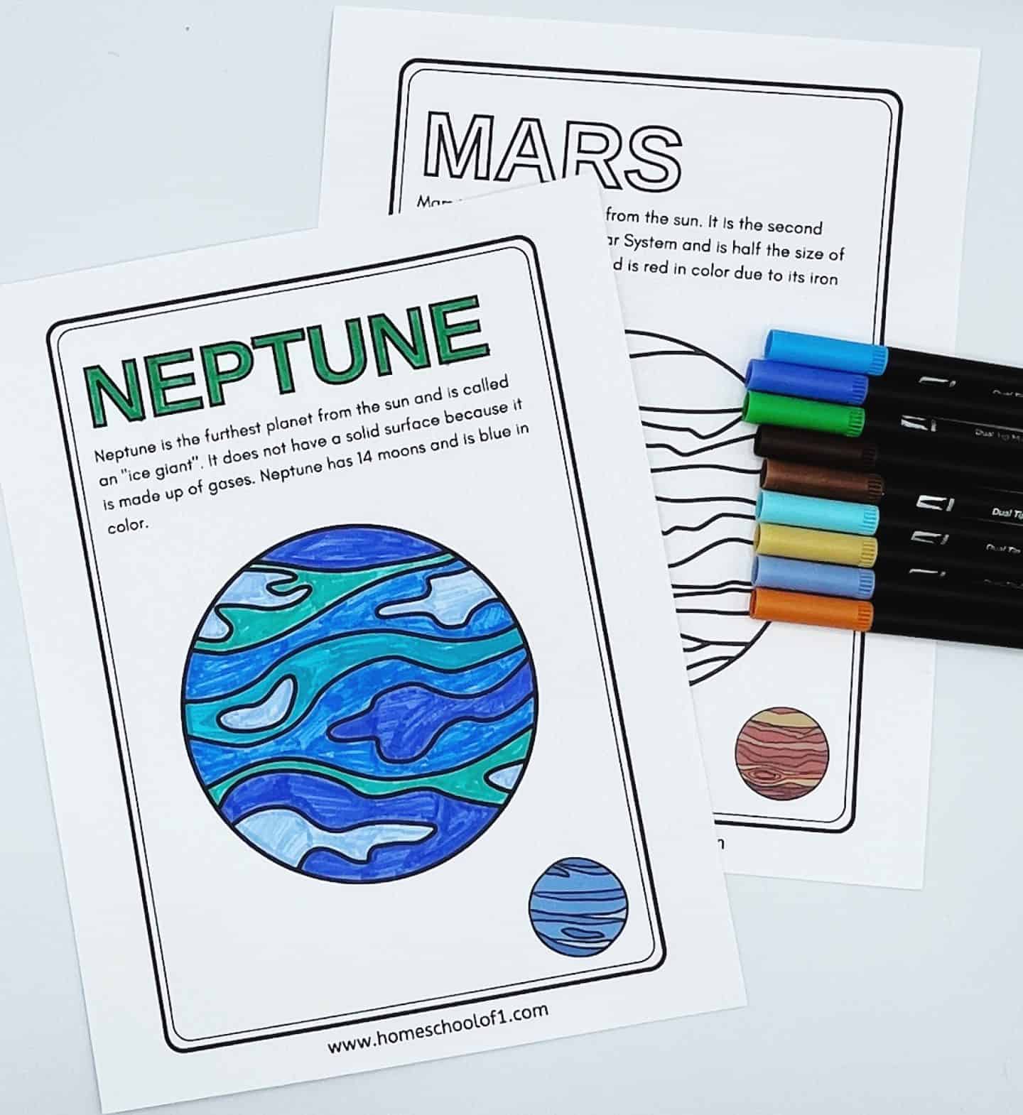 Two illustrated worksheets showing Mars and Neptune. Mars is outlined with facts about the planet, and Neptune is colored in blue and green with a description. Assorted colored pens are laid beside the worksheets.
