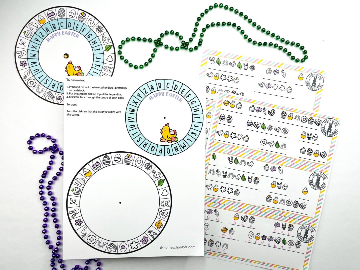 Easter-themed printable cipher wheel set featuring two cut-out cipher disks with letters and Easter icons like eggs, cupcakes, bunnies, flowers, and carrots. A printed instruction sheet explains how to assemble and align the disks to decode secret messages, such as aligning the letter "U" with the carrot. The image also shows several pastel-bordered message cards filled with Easter symbols ready to be deciphered, surrounded by green and purple beaded necklaces for festive flair.