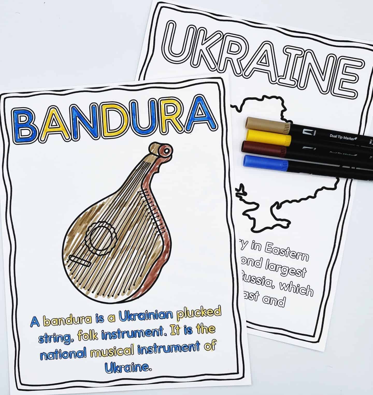 Two Ukraine-themed coloring pages, one featuring the "Bandura," a traditional plucked string folk instrument, colored in brown with the title in yellow and blue. The second page titled "Ukraine" displays a map outline of the country with some black markers and colored pens lying on top, partially obscuring the text.