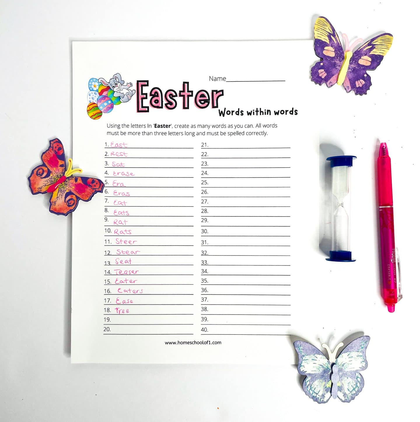 An Easter-themed “Words Within Words” worksheet is partially completed with 18 handwritten words derived from the word "Easter." The page includes colorful graphics of Easter eggs and a bunny, surrounded by decorative paper butterflies, a pink pen, and a blue sand timer, evoking a bright and springtime learning vibe.