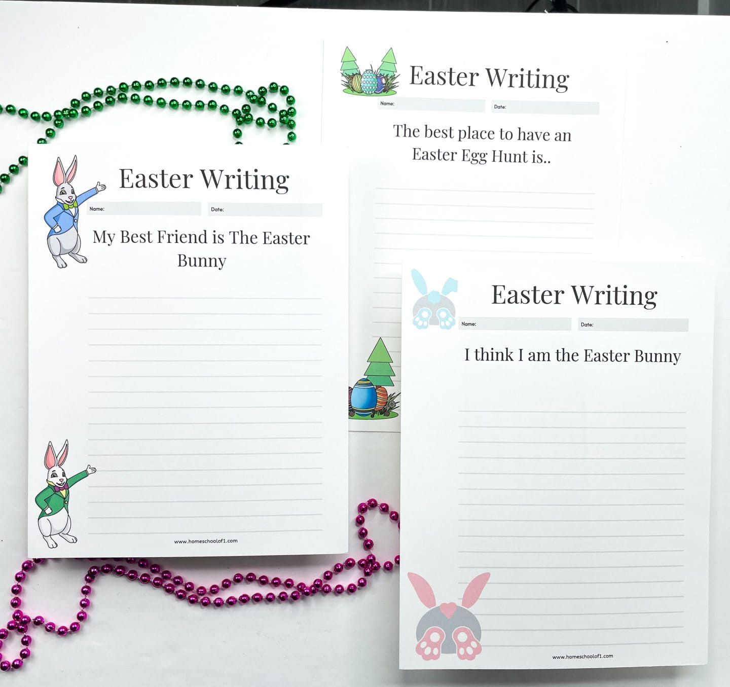 Three Easter-themed writing prompt worksheets for kids feature playful illustrations of Easter bunnies, eggs, and trees. Prompts read “My Best Friend is The Easter Bunny,” “The best place to have an Easter Egg Hunt is…,” and “I think I am the Easter Bunny.” The pages are laid out on a white surface with green and pink beaded necklaces scattered around, adding a festive spring vibe.

