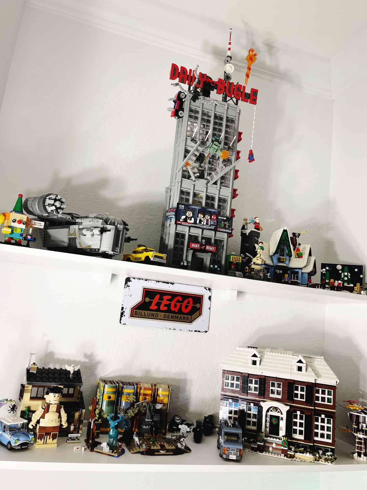 Lego Daily Bugle and Home Alone set displayed on white shelves.