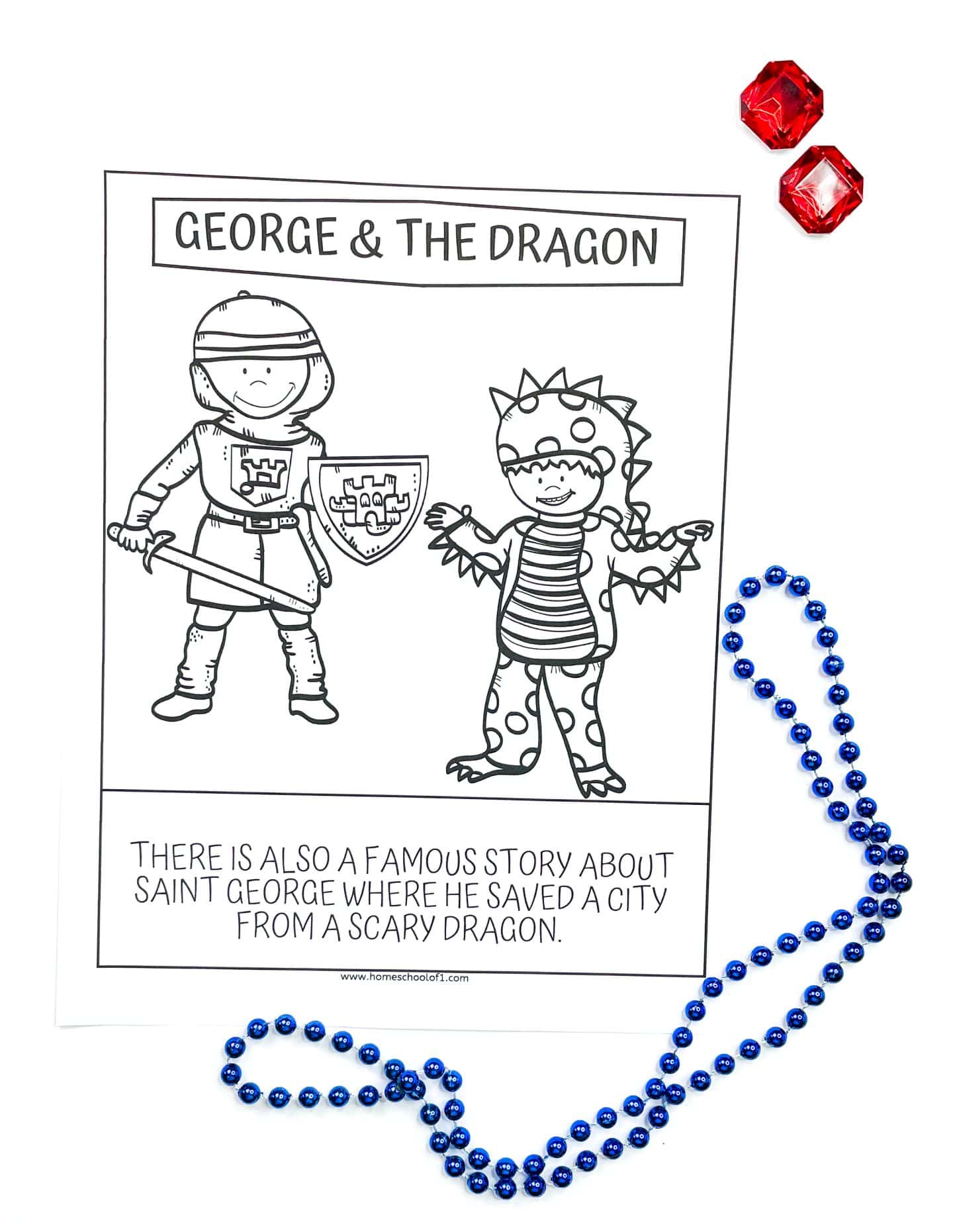A black-and-white children’s coloring page titled "George & The Dragon," showing a cartoon-style St. George in armor holding a sword and shield, standing next to a friendly-looking dragon with polka dots and spikes. The caption below reads: “There is also a famous story about Saint George where he saved a city from a scary dragon.” The page is surrounded by blue beaded necklaces and two red faux gems.

