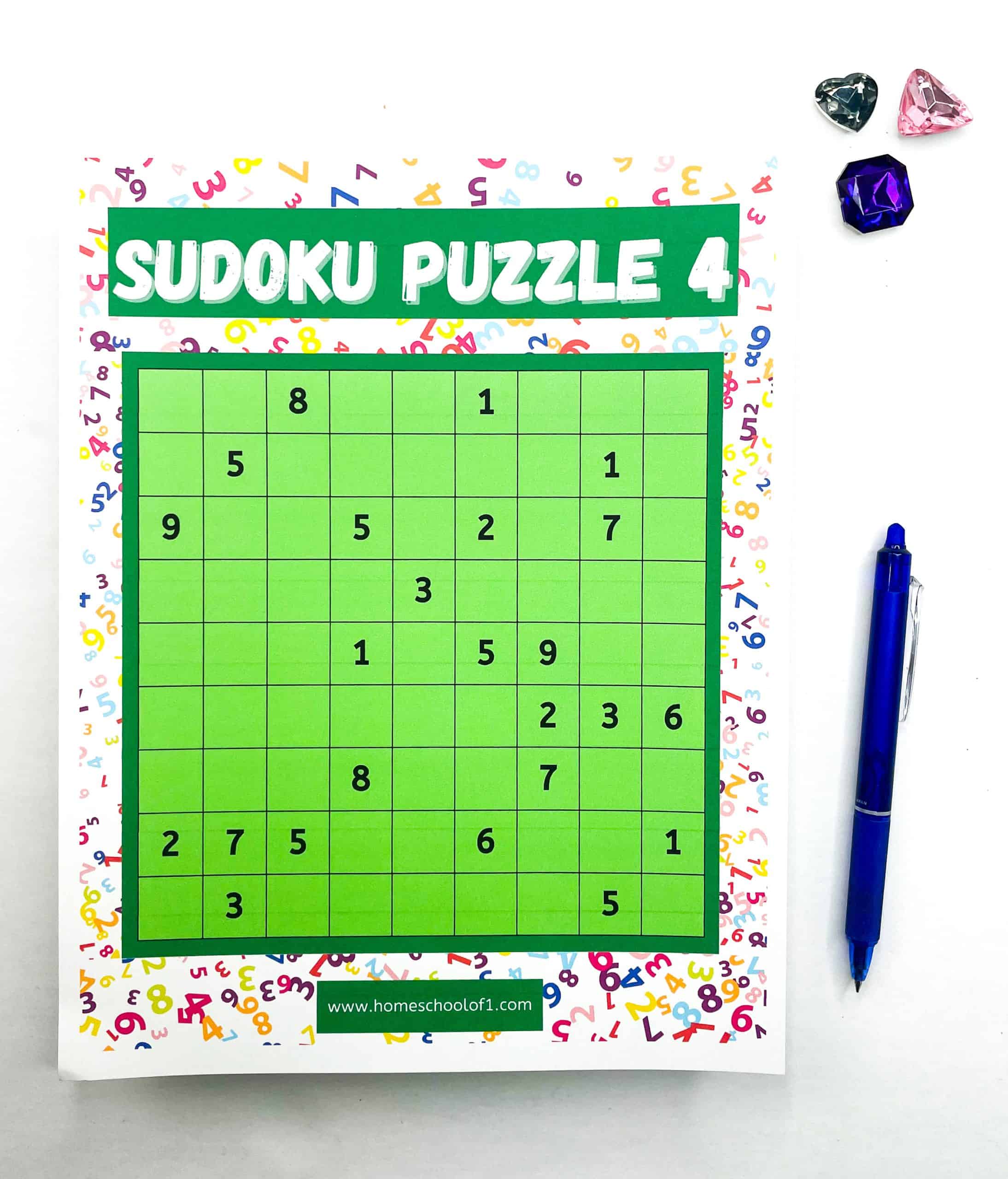 A colorful worksheet titled “Sudoku Puzzle 4” features a partially filled green Sudoku grid surrounded by a white border with multicolored numbers. A blue pen and four plastic gem-like decorations in heart and jewel shapes sit beside the puzzle. 