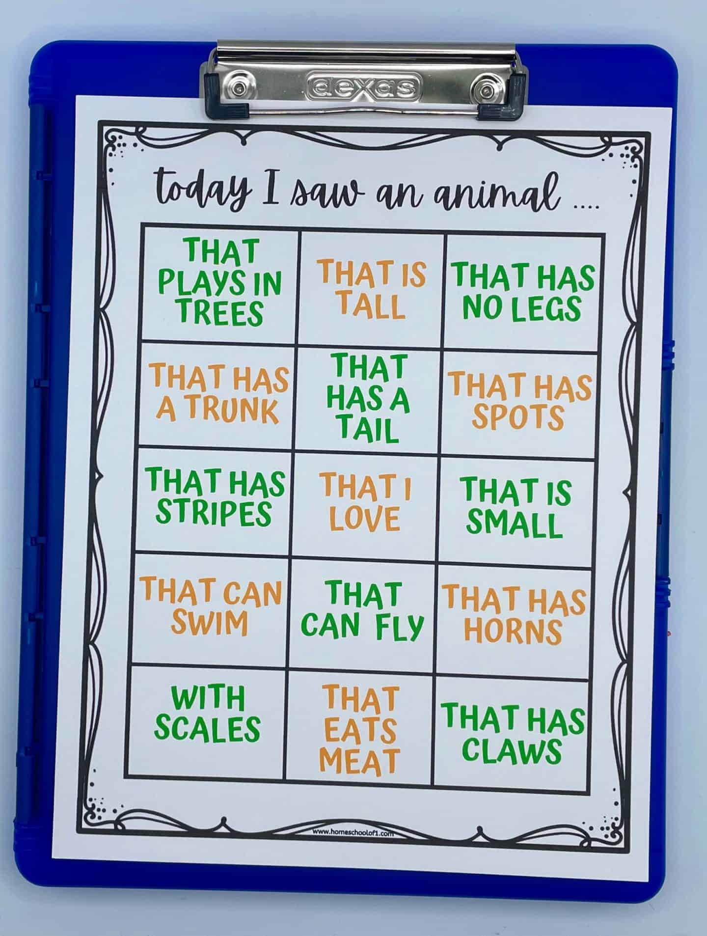 A zoo-themed bingo-style worksheet titled “Today I saw an animal...” clipped to a blue clipboard. The worksheet features a 4x5 grid with boxes describing different animal traits in green and orange text. Traits include “That plays in trees,” “That has no legs,” “That has a tail,” “That eats meat,” “That has claws,” and more. The worksheet is designed for children to mark off animals they observe at the zoo based on these characteristics.