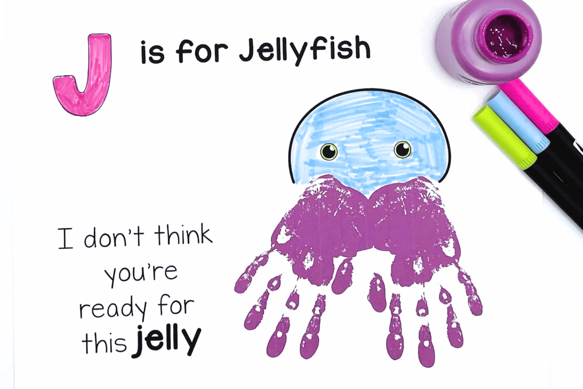 J is for jellyfish handprint craft with purple painted hands and blue jellyfish face for preschool alphabet activity