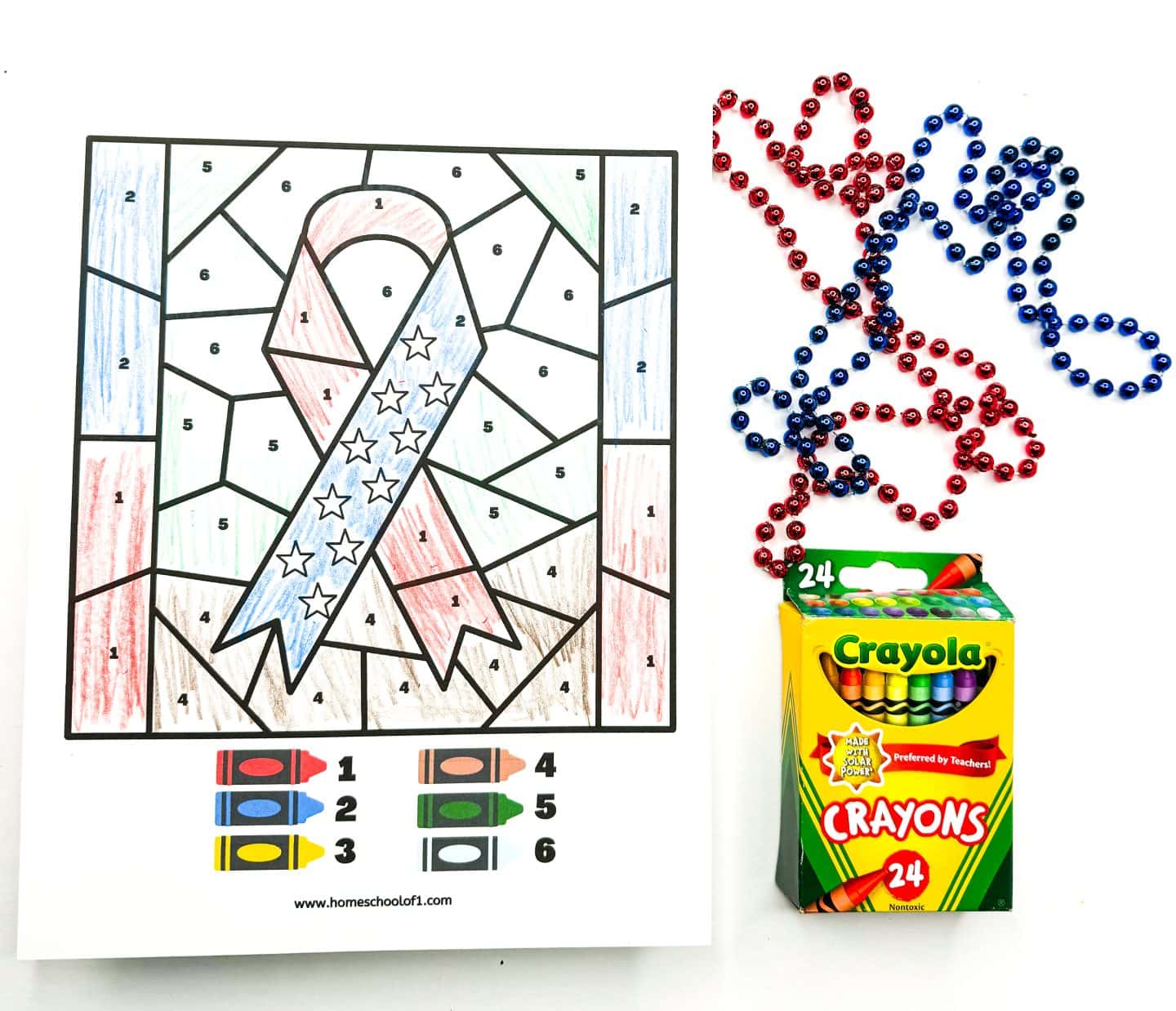 memorial day ribbon color by number completed with red, blue, yellow, brown, green and sky blue colors. with red and blue beads and crayola crayons as decoration on the right hand side. 