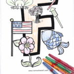 Free letter F coloring page showing a large letter F surrounded by colored images of a frog, fish, flowers, flag, and fireworks. Crayons are placed at the bottom. Text below reads "Free Letter F Coloring Page."