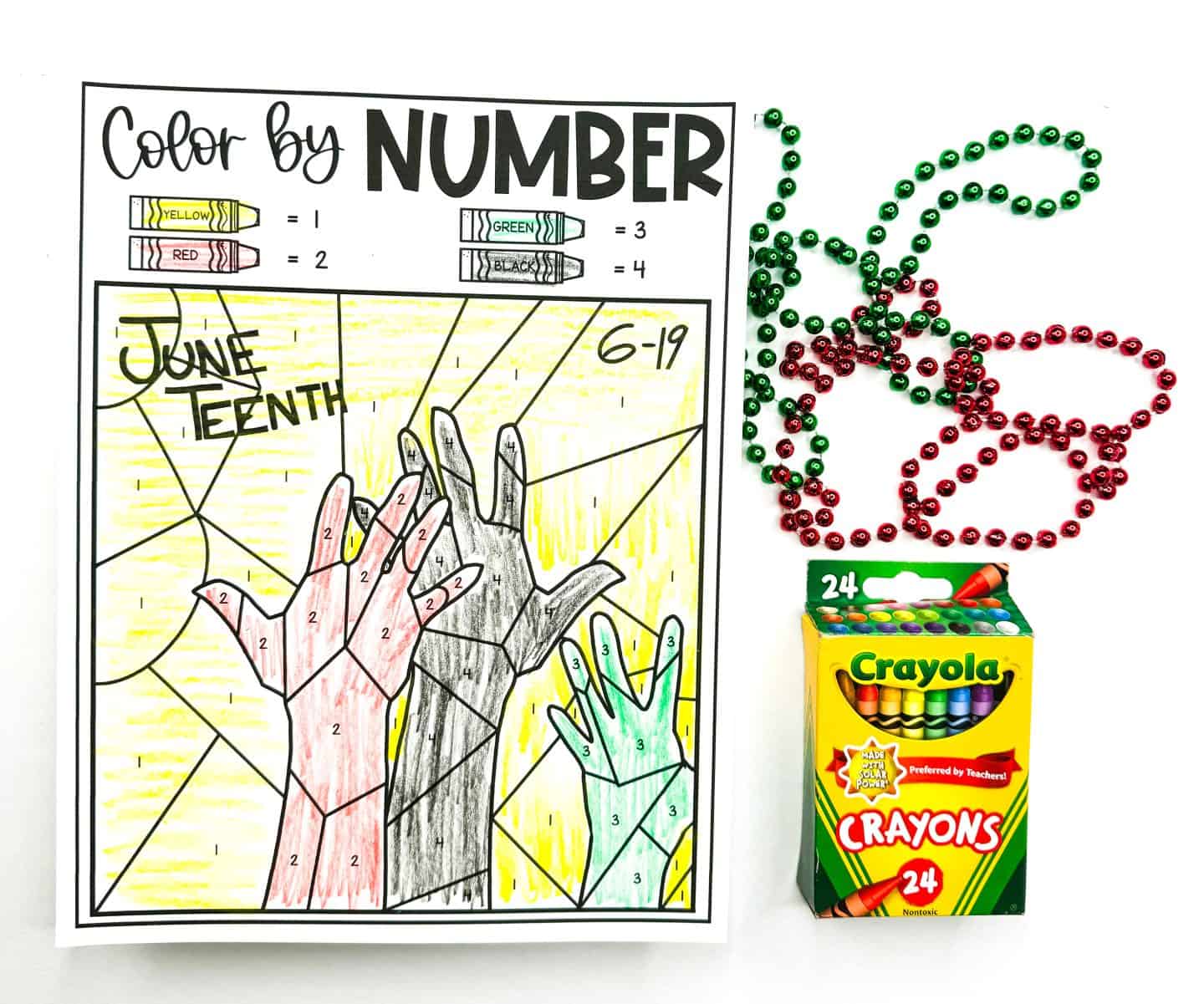 A Juneteenth color-by-number worksheet showing three raised hands in red, black, and green against a yellow background. The top of the page features a color key with yellow, red, green, and black crayons labeled with numbers. The words "June Teenth" and the date "6-19" are handwritten at the top. Beside the worksheet are red and green beaded necklaces and a box of Crayola 24-count crayons.