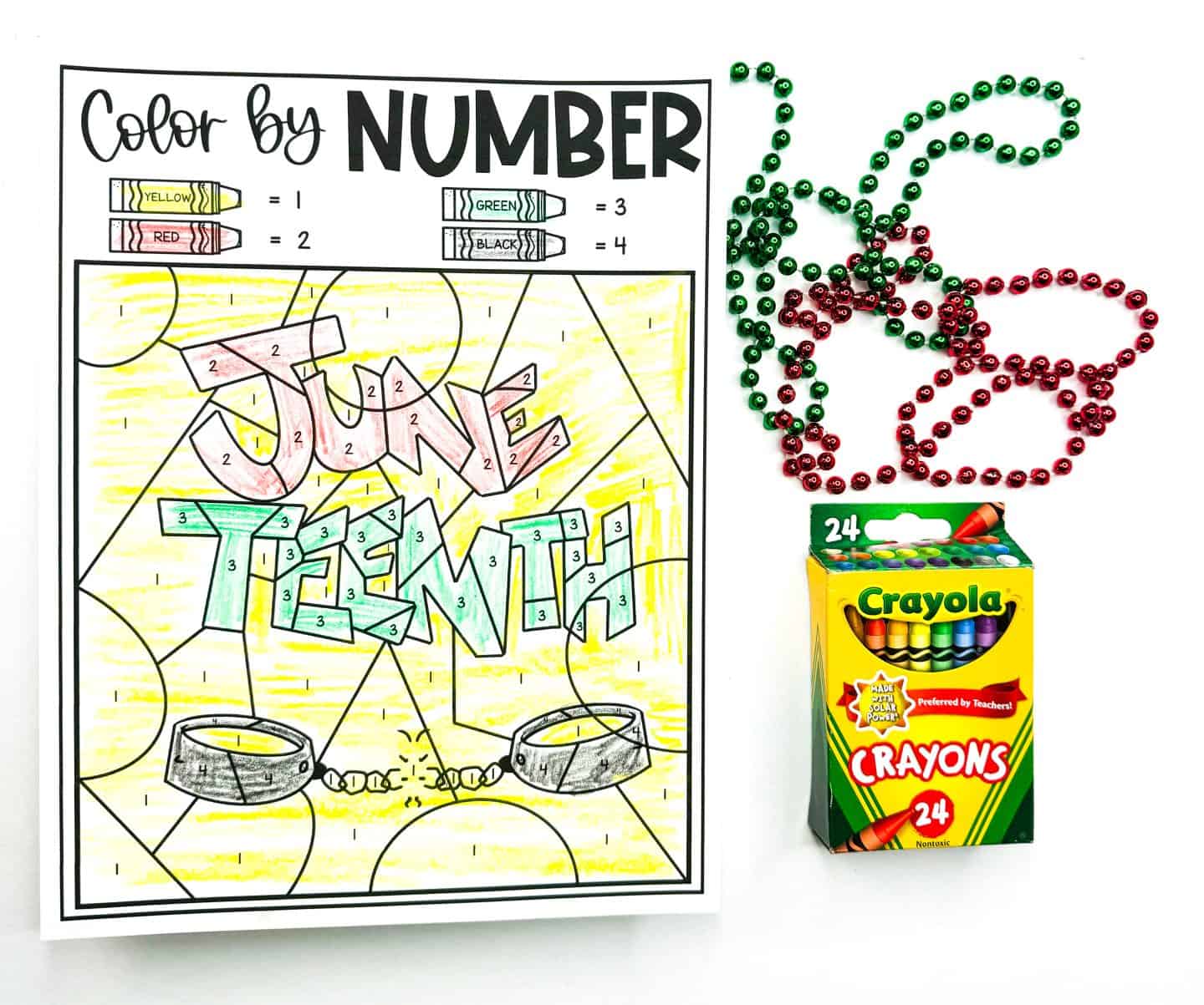 Color-by-number Juneteenth worksheet with the words “June Teenth” in bold graffiti-style letters, colored in red, green, and black over a yellow background. Below the text are two black broken shackles symbolizing freedom. A color key at the top matches crayon colors to numbers. To the right are green and red beaded necklaces and a 24-count box of Crayola crayons.

