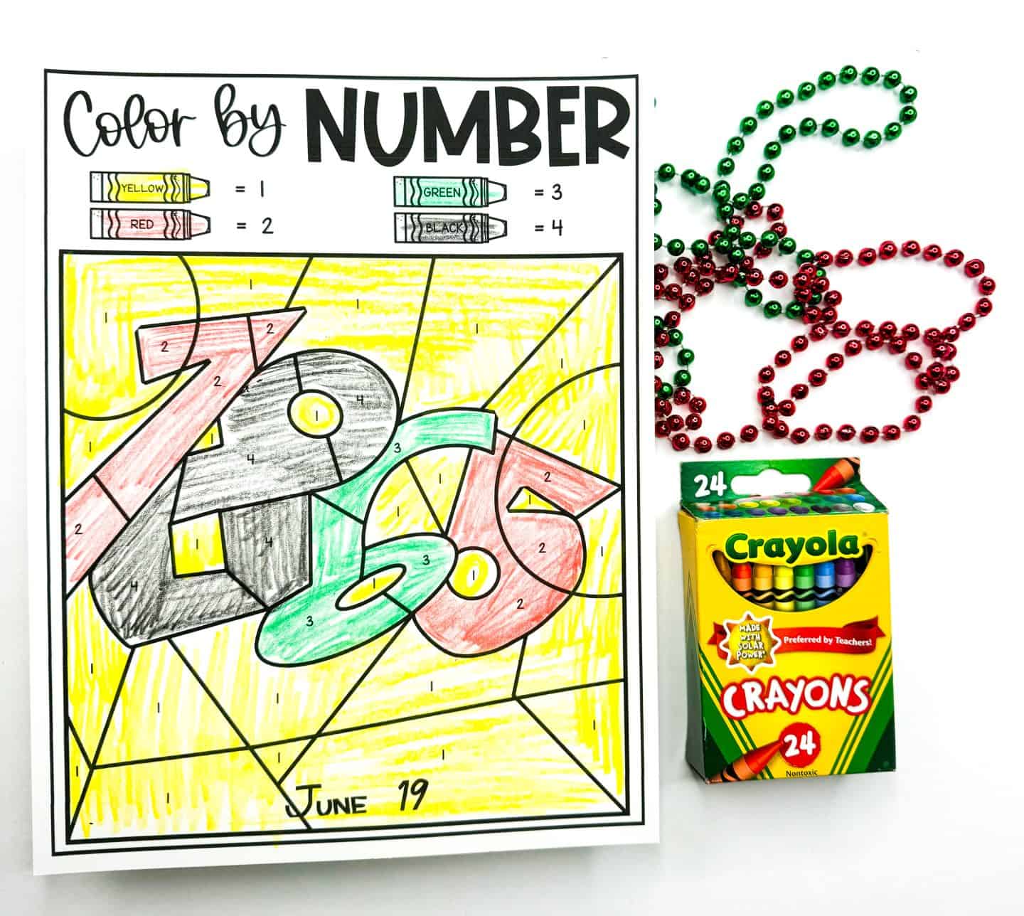 A Juneteenth color-by-number worksheet featuring the numbers "1865" in bold, stylized font, filled in using yellow, red, green, and black crayons according to a numbered key. The date "June 19" is handwritten at the bottom. The sheet is displayed next to red and green beaded necklaces and a 24-pack of Crayola crayons, creating a festive and educational vibe for celebrating Juneteenth.