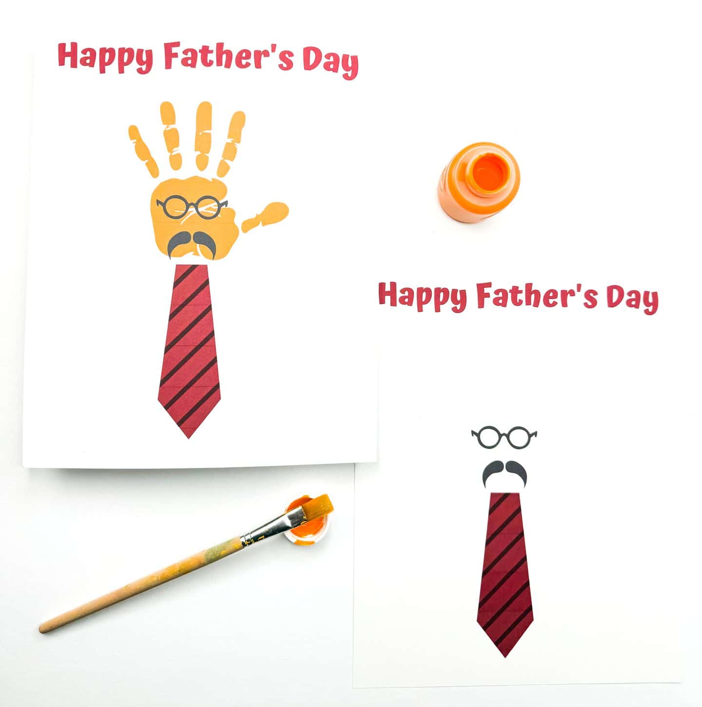 Two playful Father’s Day cards show a face made from round glasses, a mustache, and a red-striped tie, with the message “Happy Father’s Day” in bold red font. One card includes an orange handprint above the tie to complete the face, while the other is blank and ready for a print. A bottle of orange paint and brush are nearby, inviting kids to make this fun, personalized craft.