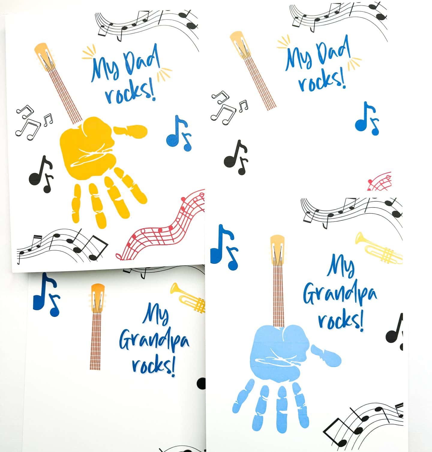 Four musical-themed Father's Day and Grandpa cards are shown, decorated with guitars, trumpets, colorful music notes, and playful fonts. Two cards say “My Dad rocks!” with one featuring a yellow handprint forming the body of a guitar. The other two say “My Grandpa rocks!” with one showcasing a blue handprint as the guitar body. These kid-friendly craft cards are surrounded by paint and perfect for gifting to musical dads and grandpas.