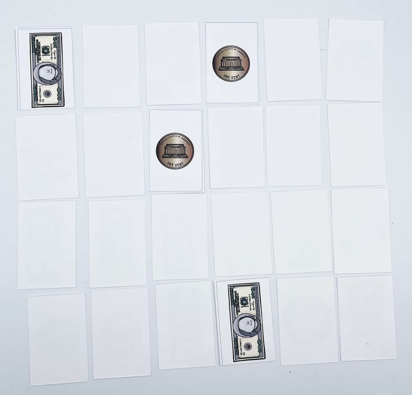 A money-themed memory game is in progress with 20 cards arranged in a grid. Some cards are flipped to reveal images of a $10 bill and one cent coins, while the rest remain face-down. The setup is on a white surface, encouraging children to match money values through play.