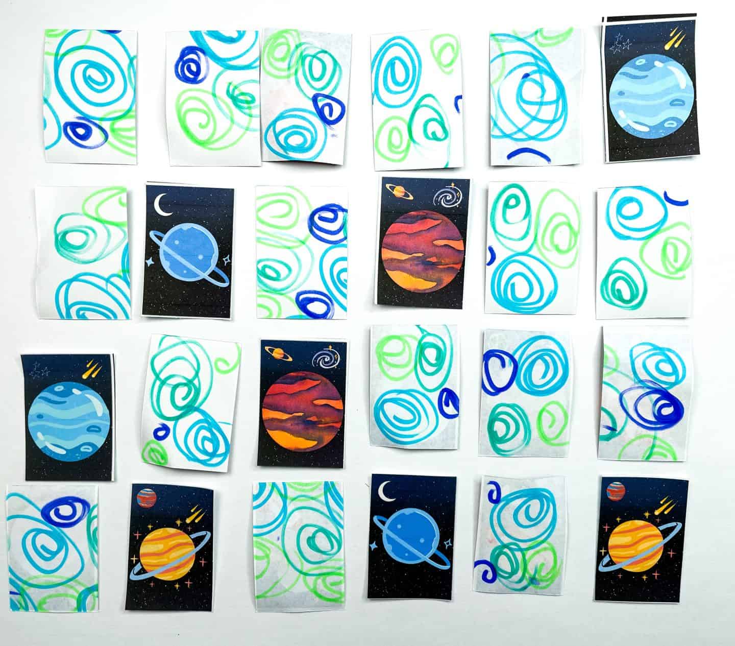 Planet-themed memory game cards laid out in a grid, with several cards flipped over showing colorful cartoon planets like Saturn, Neptune, and Mars on a starry background, while the rest display a green and blue swirl pattern on white to conceal the images.