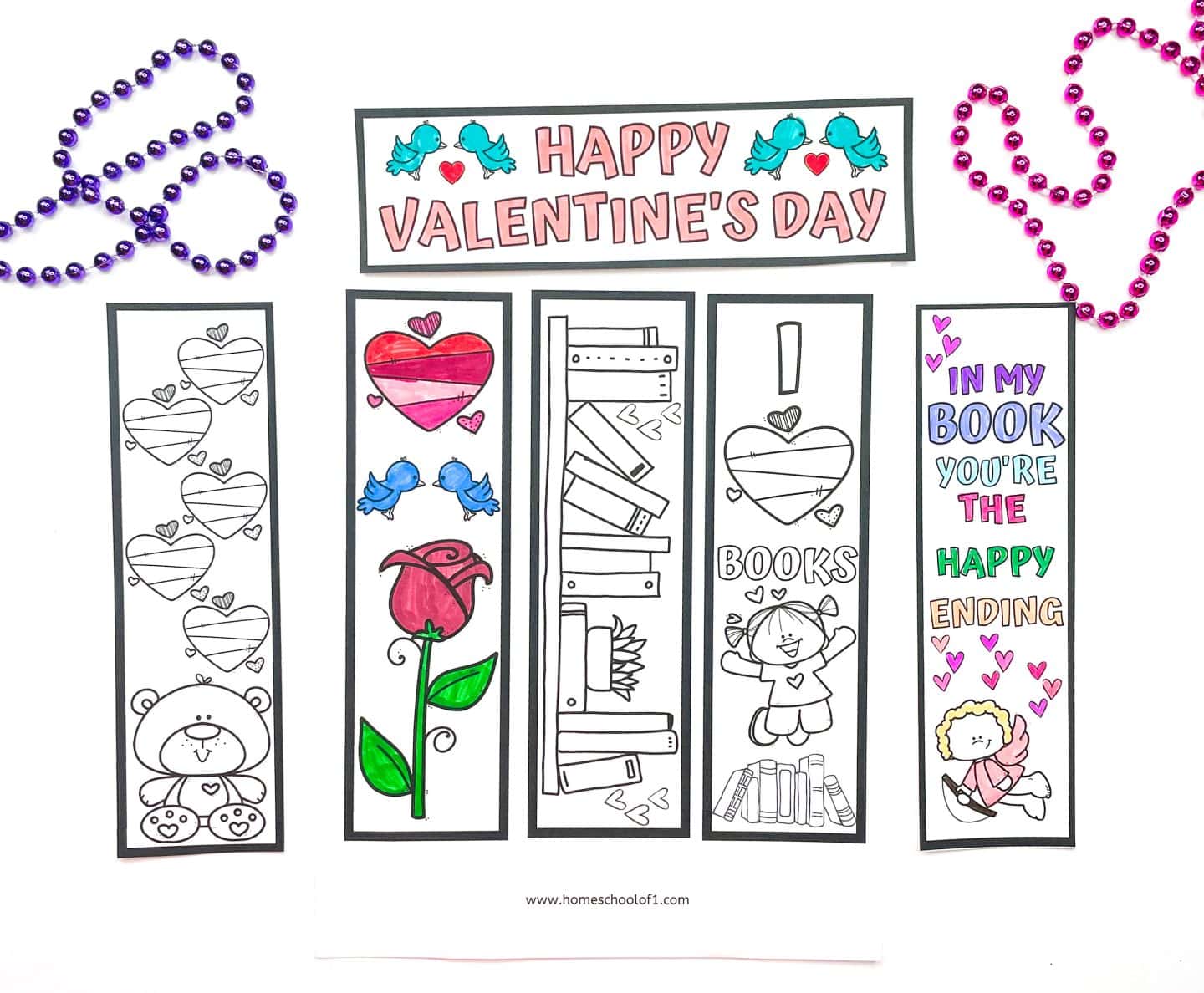 A collection of five Valentine’s Day bookmarks to color, partially filled in with colored markers. Designs include hearts, a teddy bear, a rose, books, a girl reading, and a cupid with the quote “In my book you’re the happy ending.” A “Happy Valentine’s Day” banner with blue birds and hearts is placed above the bookmarks, surrounded by pink and purple bead necklaces.