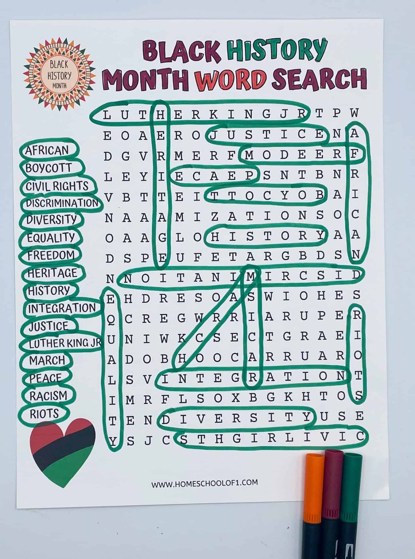 A completed Black History Month word search worksheet with several terms circled in green marker. Words on the list include “Luther King Jr,” “Civil Rights,” “Freedom,” “Equality,” “Racism,” and “Heritage.” The title “Black History Month Word Search” is printed in bold red and green letters at the top, and a heart in Pan-African flag colors is at the bottom left. Three markers—orange, maroon, and green—are placed in the lower right corner.

