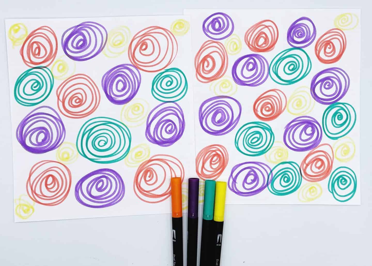 Two sheets of printed Easter memory game card backs, decorated with colorful hand-drawn swirl patterns in purple, red, green, and yellow. Four markers in matching colors—orange, purple, black, and yellow—are placed at the bottom, indicating they were used to create the designs. The swirly pattern adds a playful and vibrant touch to the card game from homeschoolof1.com.