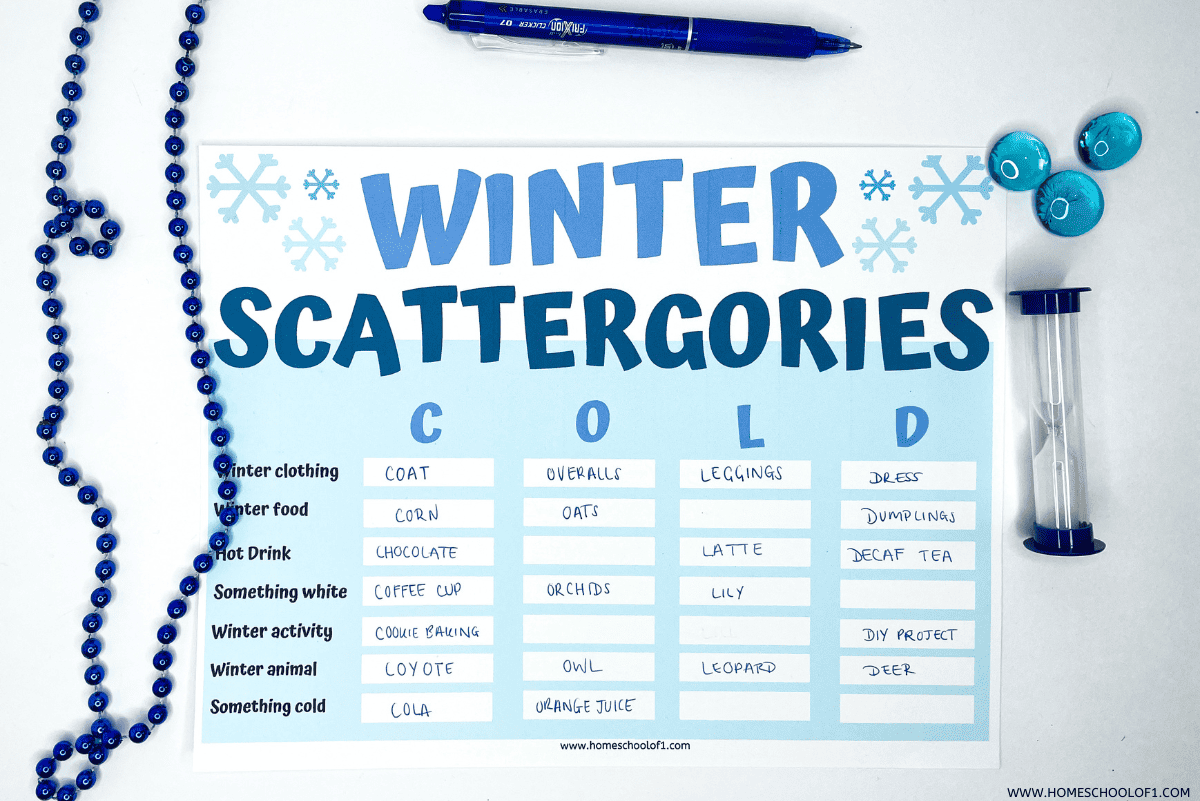 A completed “Winter Scattergories” game sheet with categories like Winter Clothing, Winter Food, Hot Drink, Something White, Winter Activity, Winter Animal, and Something Cold. Each column is filled in for the letters C, O, L, and D with answers like “Coat,” “Overalls,” “Latte,” and “Dumplings.” The sheet is surrounded by a blue pen, an hourglass timer, blue beaded garland, and blue game markers on a white background.