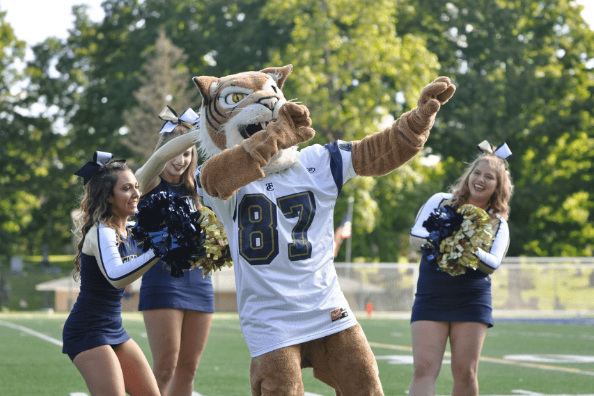 Thiel Athletics Program Tomcats mascot surrounded by cheerleaders