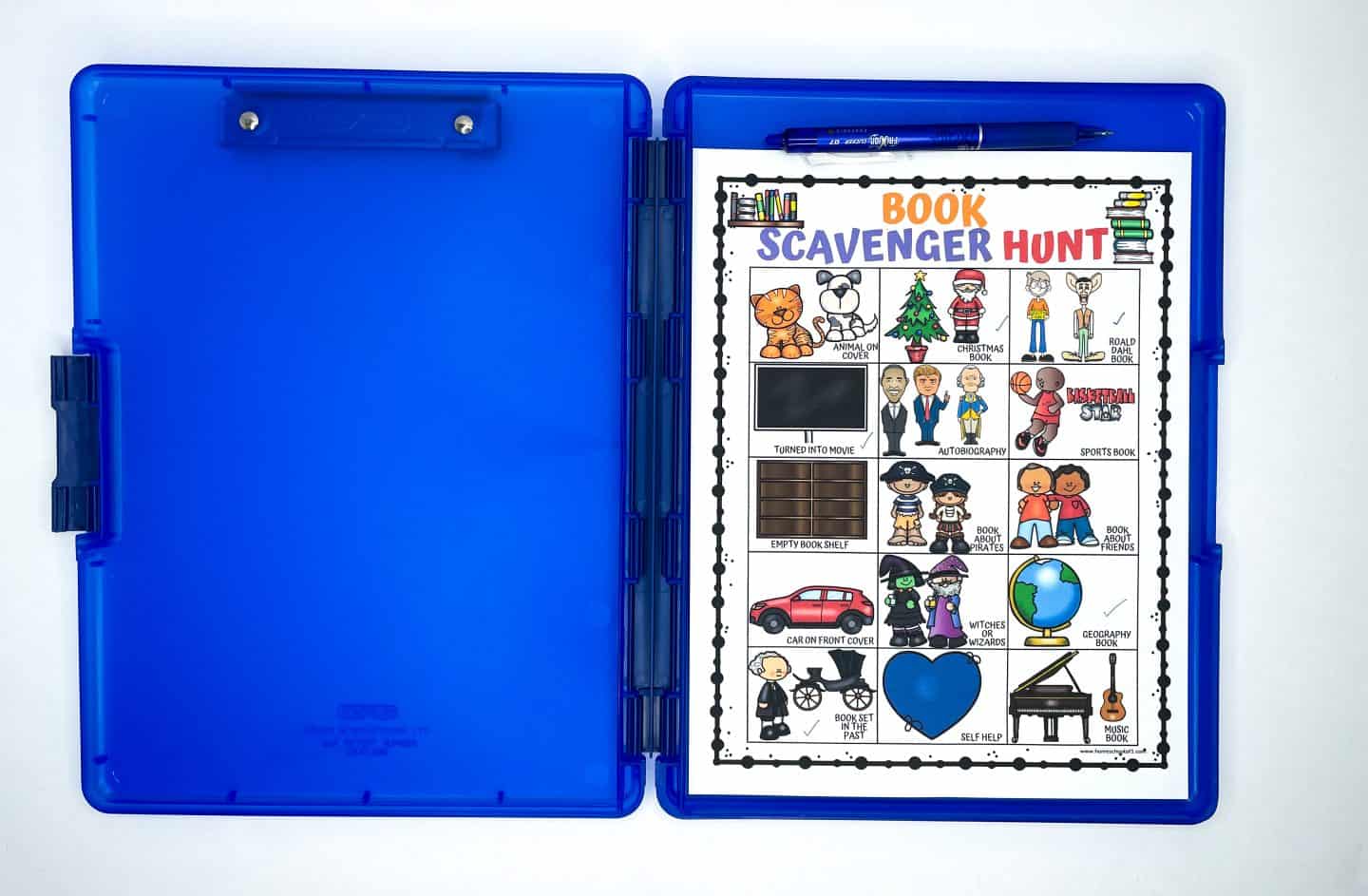 A colorful Book Scavenger Hunt printable is clipped inside a bright blue plastic clipboard storage case. The sheet includes illustrated prompts such as “Animal on Cover,” “Autobiography,” “Book About Pirates,” and “Turned Into Movie.” A blue pen is placed in the clip at the top of the case. The setup is clean and organized, ideal for taking the scavenger hunt to the library or classroom for an interactive reading activity.