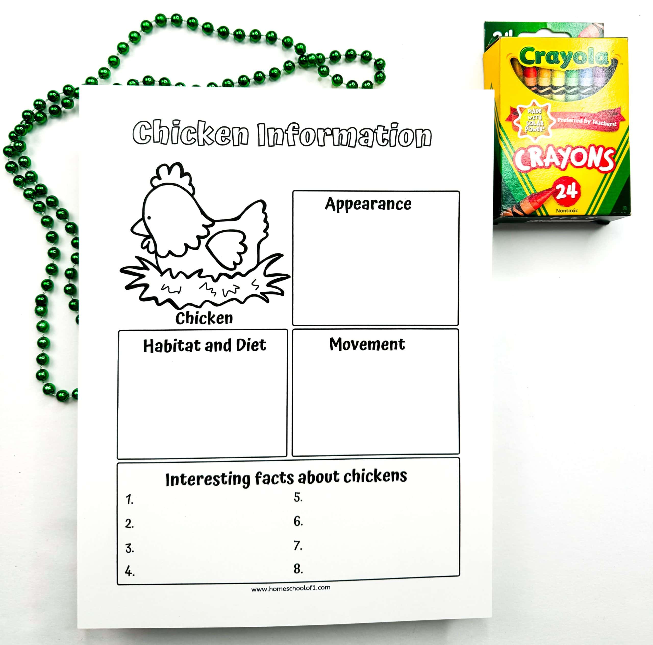 Black-and-white chicken information worksheet for kids with a cartoon chicken in a nest and labeled sections for writing about appearance, habitat and diet, movement, and interesting facts about chickens. A green beaded necklace and a box of Crayola crayons are placed next to the sheet on a white background.