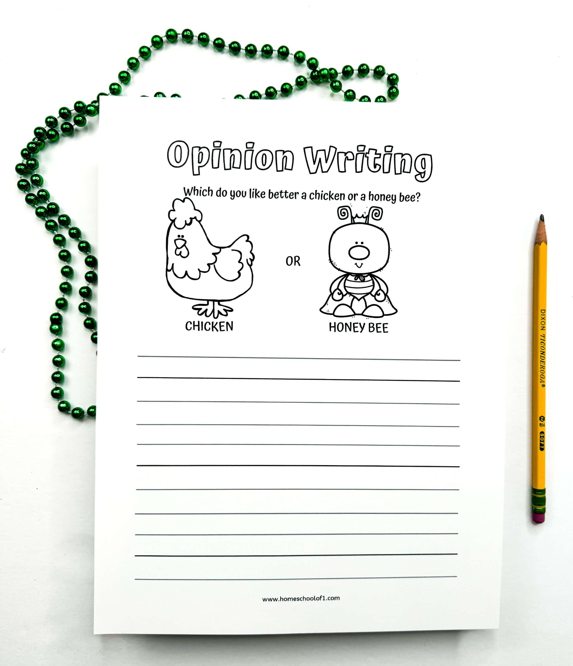 Black-and-white opinion writing worksheet for kids featuring a cartoon chicken on the left and a cartoon honey bee on the right, with the prompt “Which do you like better a chicken or a honey bee?” followed by several lines for students to write their response. A pencil and a green bead necklace are placed beside the sheet on a white background.