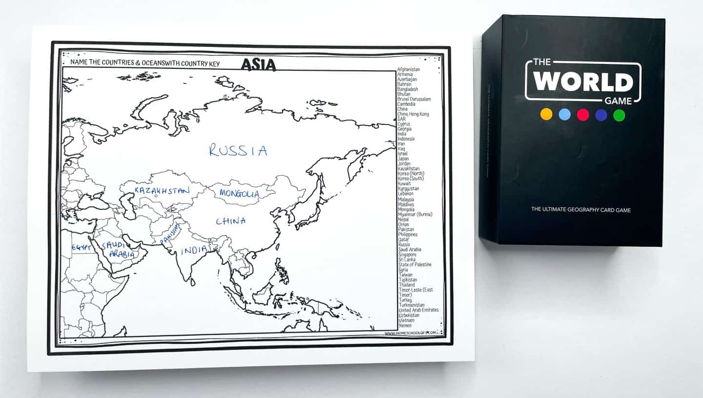 Black-and-white printable map of Asia with several countries labeled in blue handwriting, including Russia, China, India, Kazakhstan, Mongolia, Saudi Arabia, Egypt, and Pakistan. A country name key is listed along the right side, and a black box labeled “The World Game – The Ultimate Geography Card Game” is placed to the right of the worksheet.