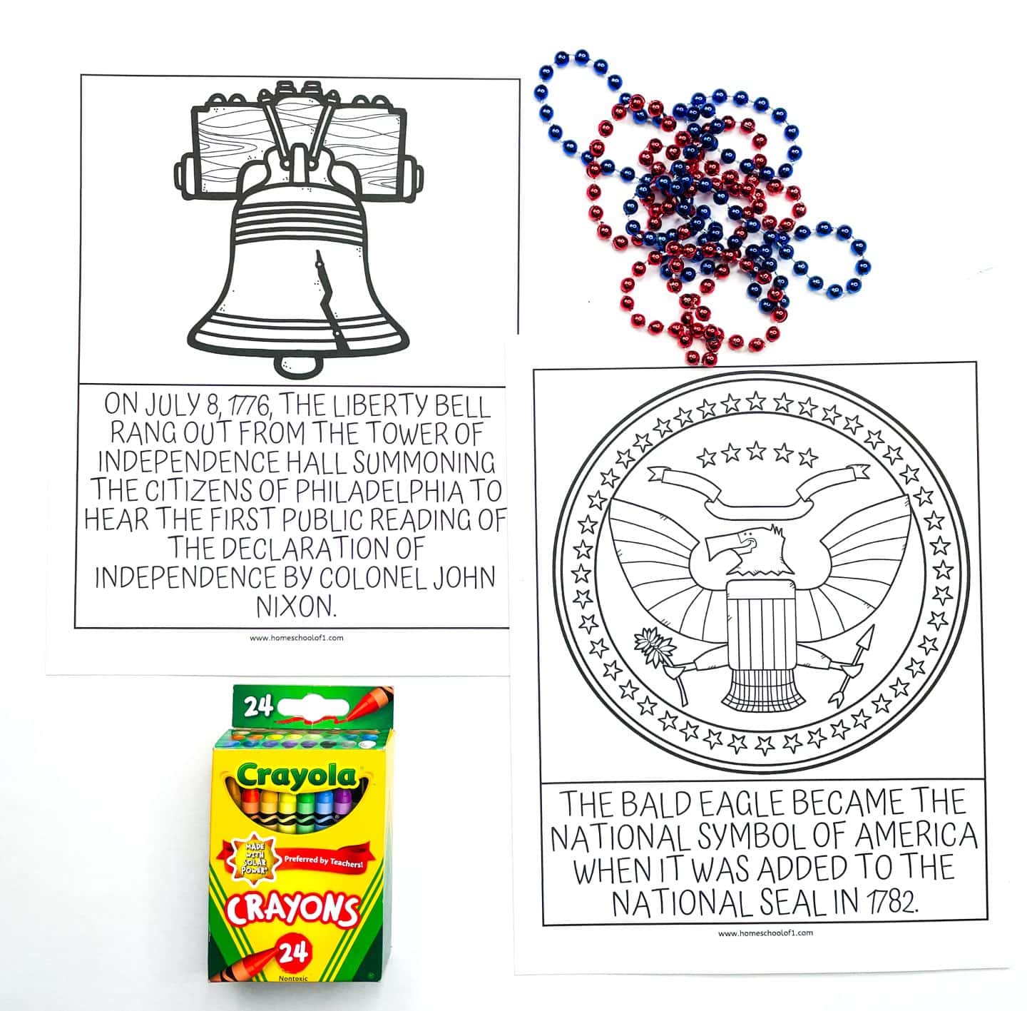 two worksheets related to the Declaration of Independence. One shows a line drawing of the Liberty Bell with text explaining its significance during the public reading of the Declaration in 1776. The other worksheet displays a line drawing of the national seal featuring a bald eagle, with text about it becoming the national symbol in 1782. A box of Crayola crayons and red and blue beads are also visible.