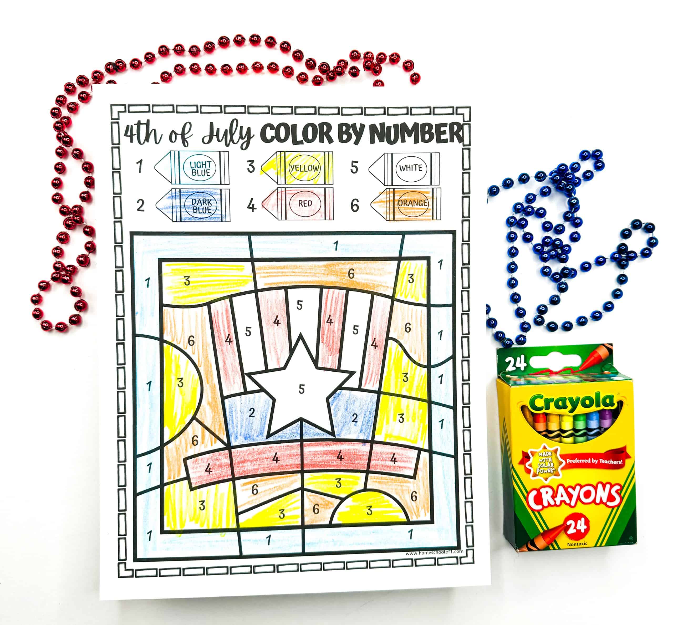 A completed 4th of July color-by-number worksheet features a large central star surrounded by red, yellow, blue, and orange patterns, filled in according to a numbered crayon key at the top. The coloring page is framed by red and blue bead necklaces and a 24-pack of Crayola crayons, enhancing the festive and patriotic theme.
