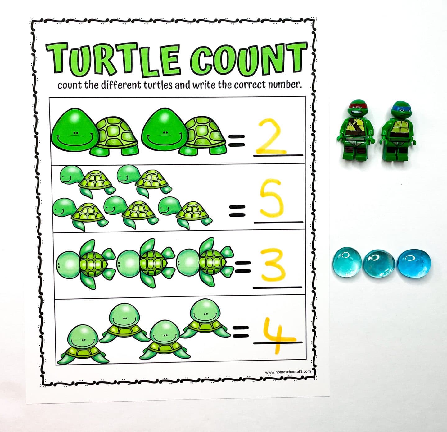 Turtle-themed preschool counting worksheet titled "Turtle Count" featuring four rows of different cartoon turtle designs. Each row asks the child to count and write the number of turtles, with the correct answers—2, 5, 3, and 4—written in yellow. To the side are two green turtle LEGO minifigures and three blue glass counting gems.