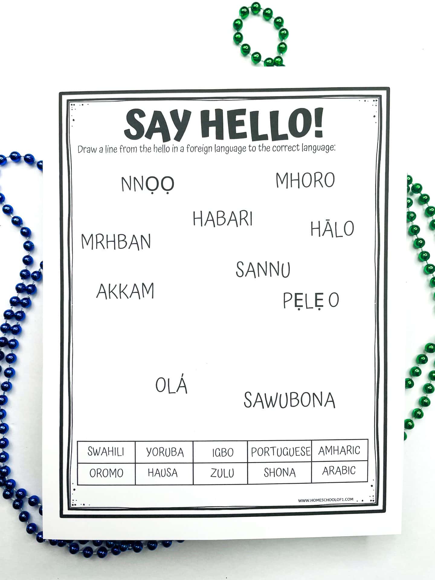 Black and white worksheet titled “Say Hello!” showing different ways to say hello in various African languages, with a matching activity where students draw lines from greetings like “Habari,” “Olá,” and “Sawubona” to languages such as Swahili, Portuguese, and Zulu. Blue and green bead strands border the page.