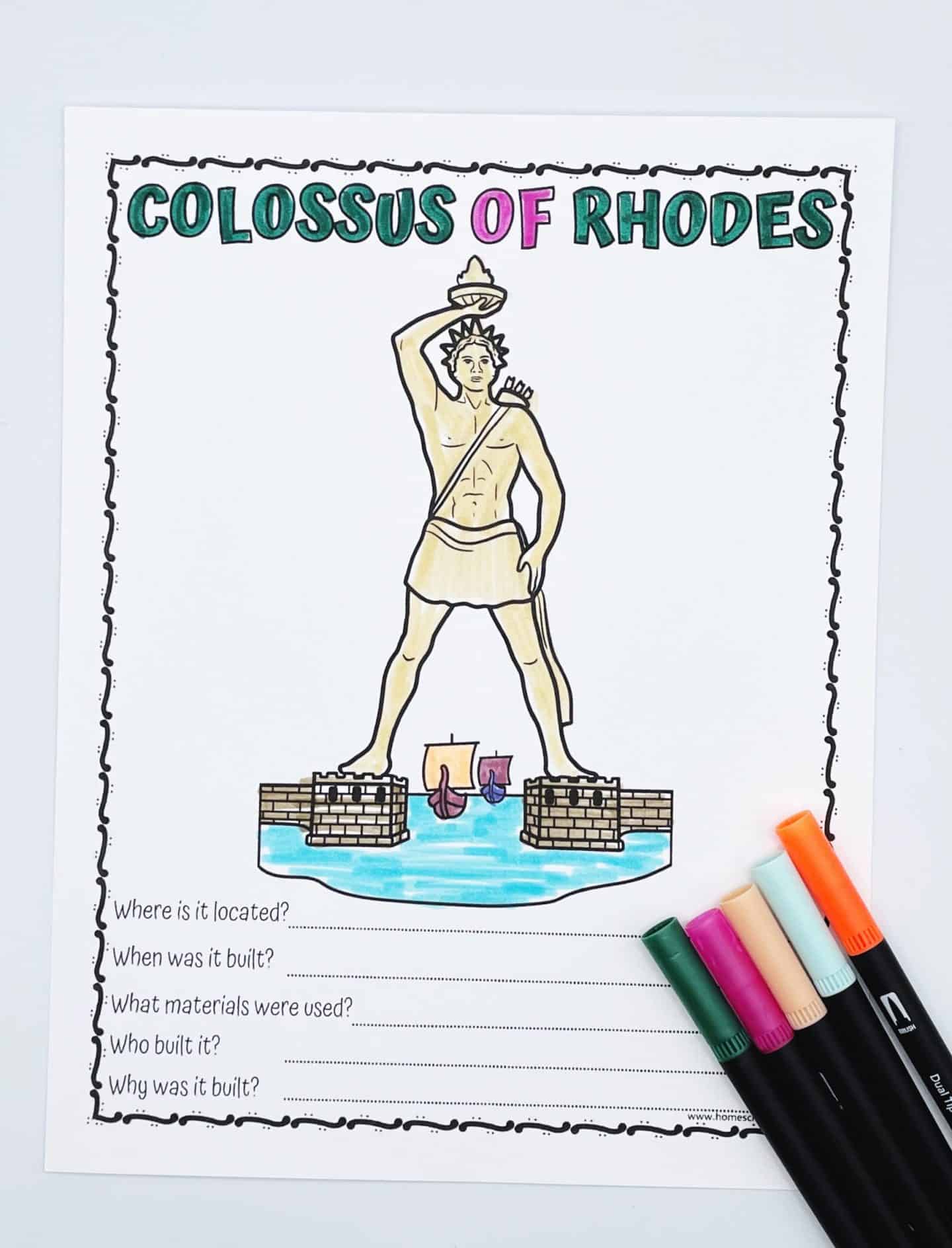 Colored worksheet featuring the Colossus of Rhodes with a large, hand-drawn statue between two towers over water, and five historical questions below. Five markers—orange, blue, pink, green, and black—are arranged beside the sheet.