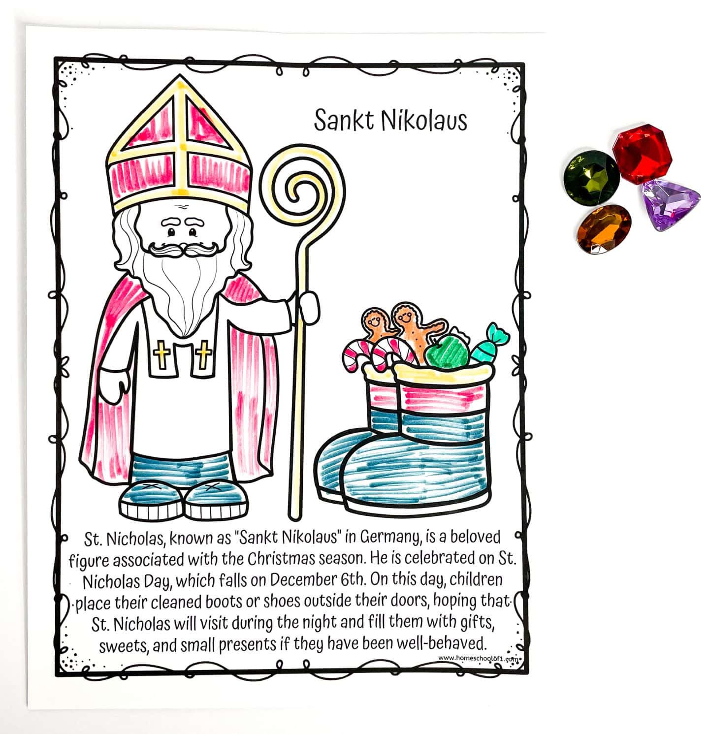 Coloring page of Sankt Nikolaus, the German version of St. Nicholas, showing him in a red and white bishop’s outfit with a golden staff. Next to him is a pair of boots filled with candy canes, gingerbread cookies, and wrapped gifts. The text below explains the tradition of children placing shoes out on December 6th to receive treats if they’ve been good. Four plastic gem decorations are positioned in the top right corner.