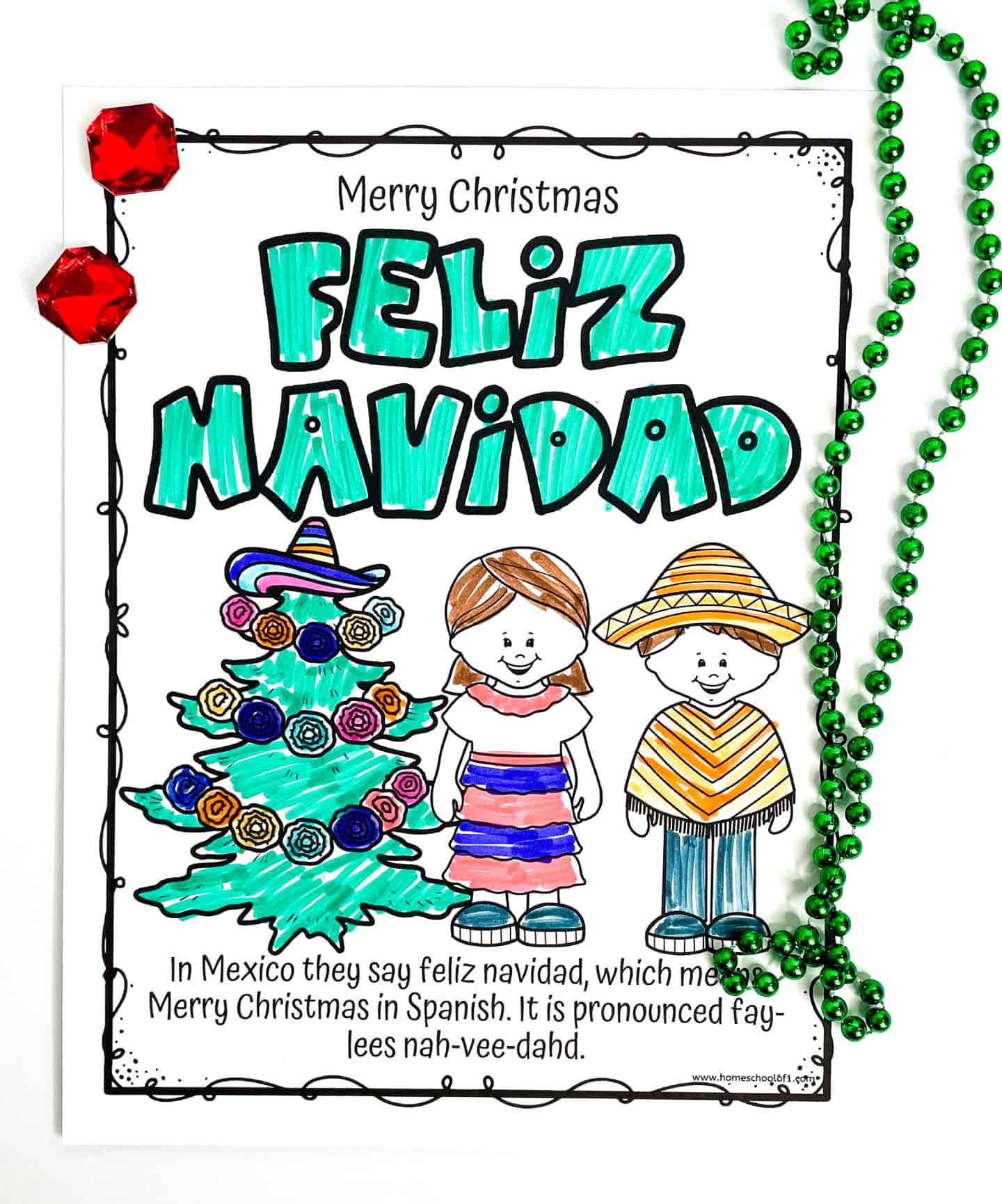 Coloring worksheet titled "Feliz Navidad" with the text "Merry Christmas" above it, showing a decorated Christmas tree wearing a sombrero and two children in traditional Mexican clothing. Below is an explanation that "Feliz Navidad" means "Merry Christmas" in Spanish, with its pronunciation written out. The page is surrounded by green beads and red gem decorations.







