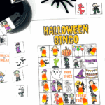 Printable Halloween bingo board surrounded by calling cards and a glittery spider prop, designed for kids’ Halloween parties.