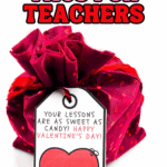 Teacher Valentine tag with heart design tied onto a pink fabric-wrapped gift.